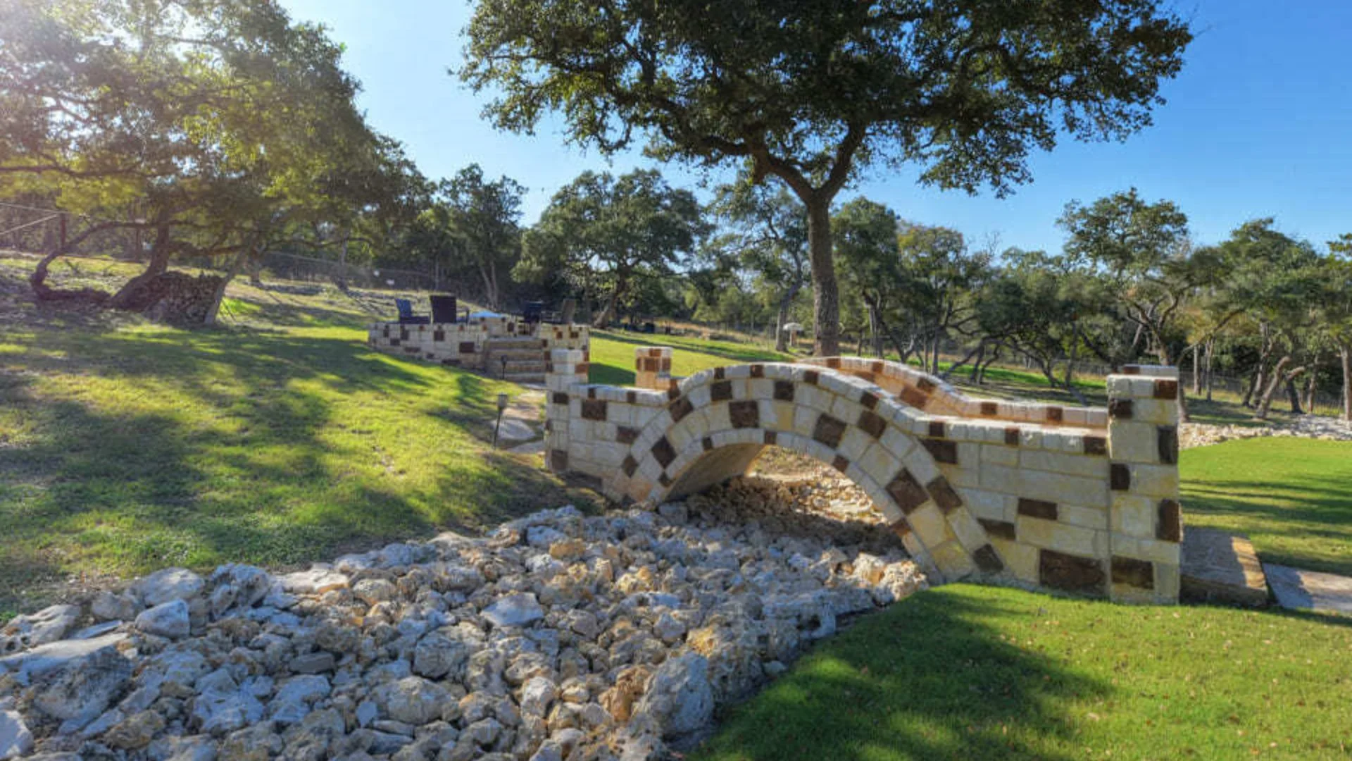 Raised Patio & Fire Pit, Bridge, & Landscape Lighting Installation in Garden Ridge, TX