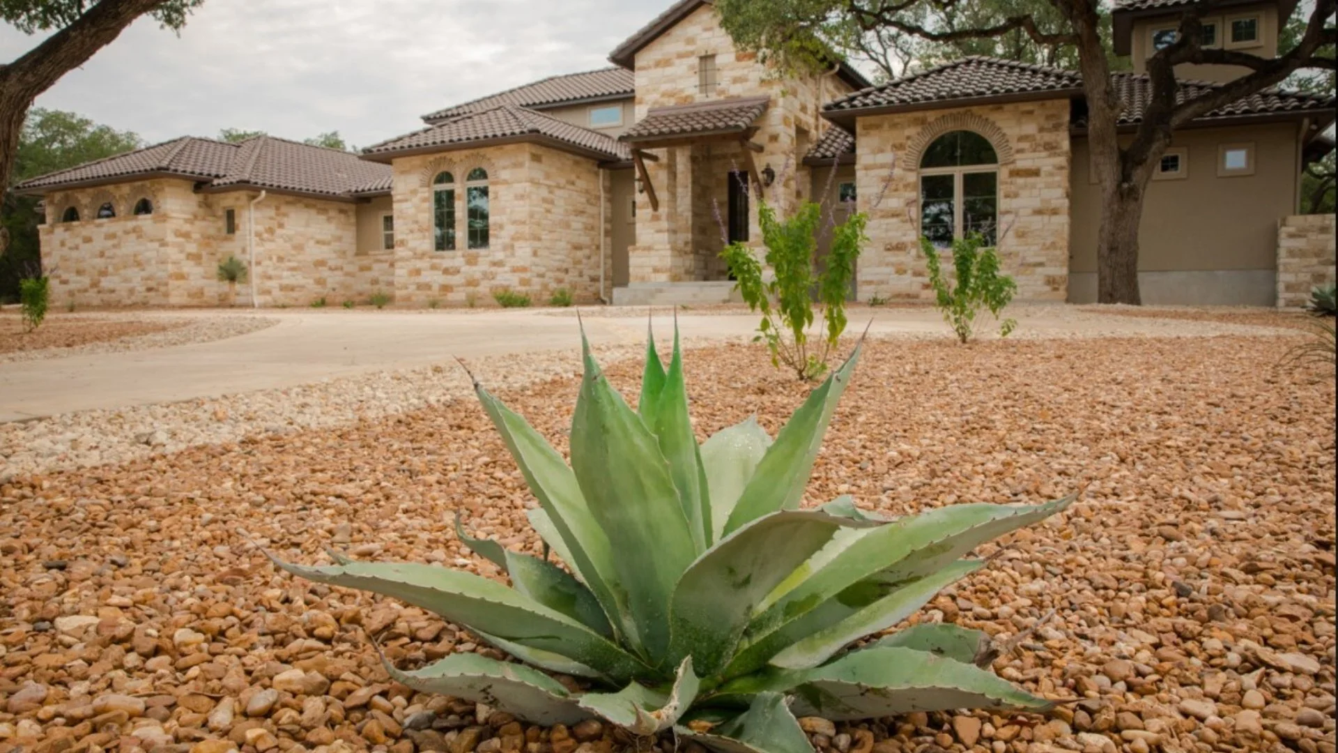 Low-Maintenance Landscaping Project With Rocks, a Walkway & Patio in Fischer, TX