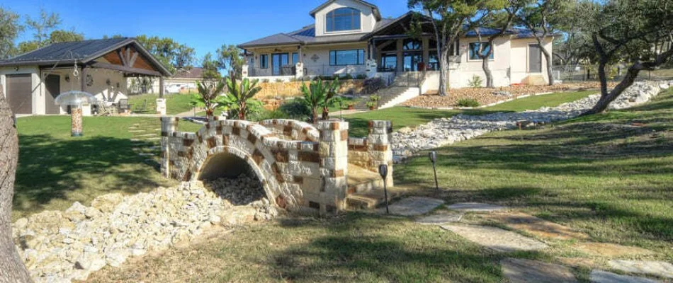 Yard in New Braunfels, TX, with French drain and small bridge.