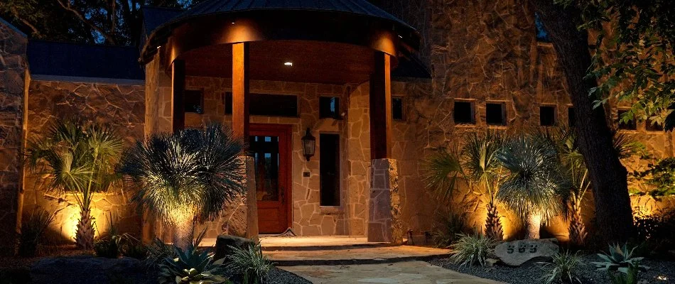 House in New Braunfels, TX, with tropical plants and warm white lighting.