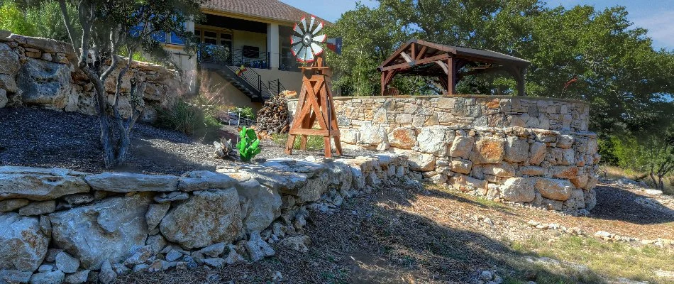 Retaining wall with pavilion and decor in New Braunfels, TX.